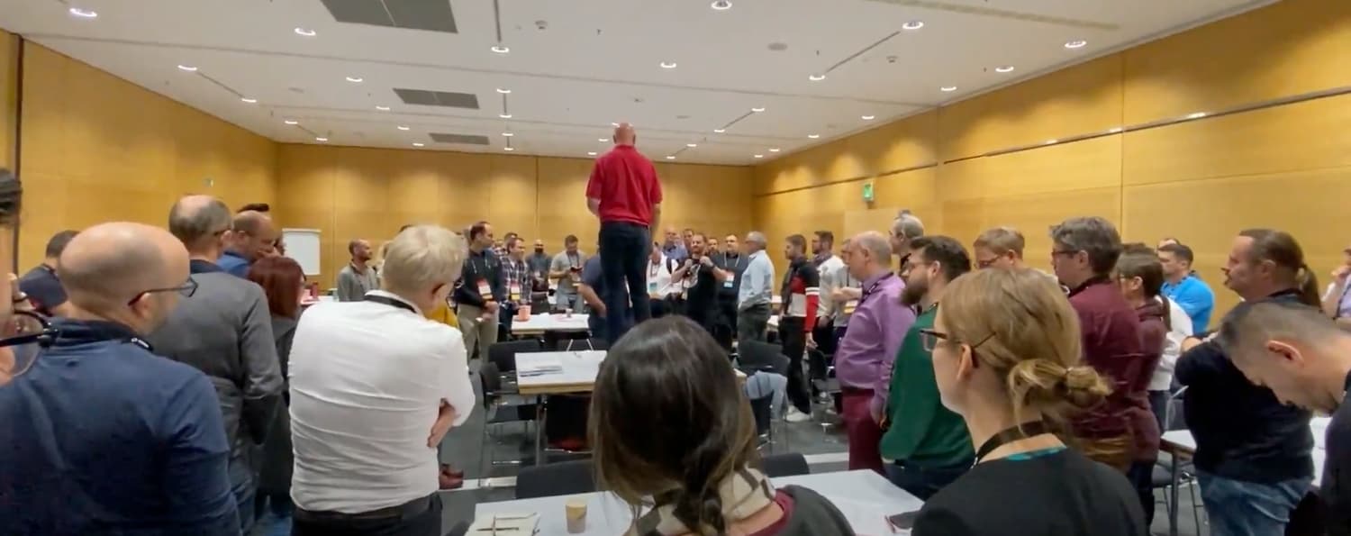 Workshop participants gathered around tables during a SAFe session.
