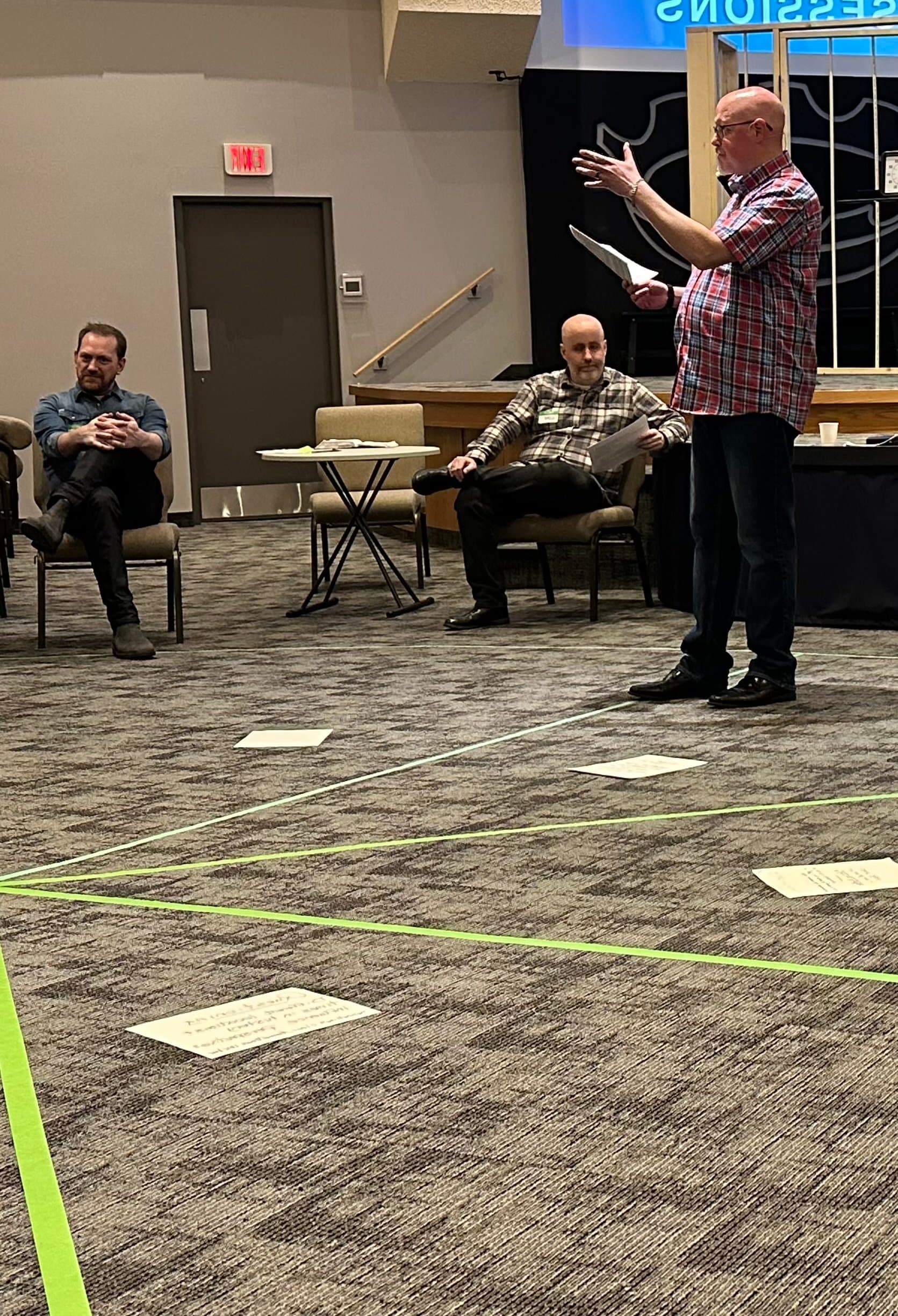 Brock Argue running an agile and scrum training class in Calgary with students seated in a circular arrangement.
